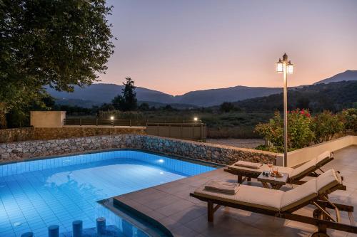 a swimming pool with a table and chairs next to it at Villa Nature, Heated Pool in Kalyves