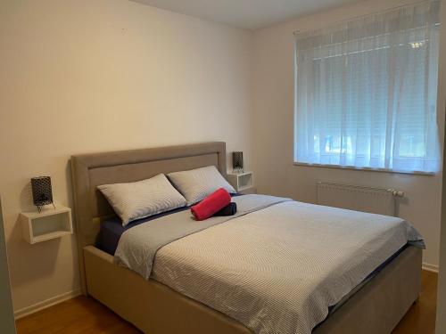 Un dormitorio con una cama con una almohada roja. en Apartman MERI, en Strmec Samoborski