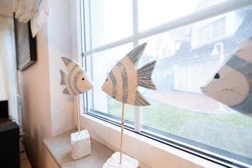 two paper fish decorations on a window sill at Strandglück 3 in Zingst