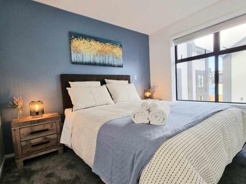 a bedroom with a large bed with towels on it at Elegant CBD Apartment in Christchurch