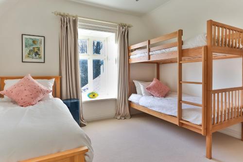 una camera con 2 letti a castello e una finestra di Windrush a Colesbourne