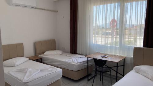 a room with two beds and a table and a stop sign at Ayvaz Otel in Torbalı