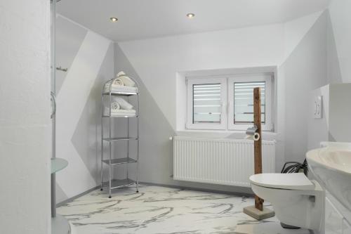ウムハウゼンにあるHaus Attosのバスルーム(トイレ、洗面台付)、窓が備わります。