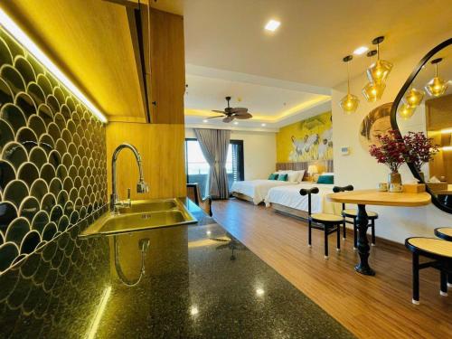 uma cozinha com um lavatório e uma cama num quarto em ST Apartment - FLC SeaTower Quy Nhon em Quy Nhon