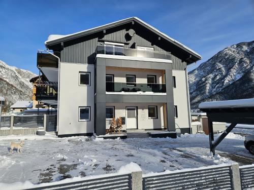a house in the snow in front of a mountain at Appartements Am Achensee in Pertisau
