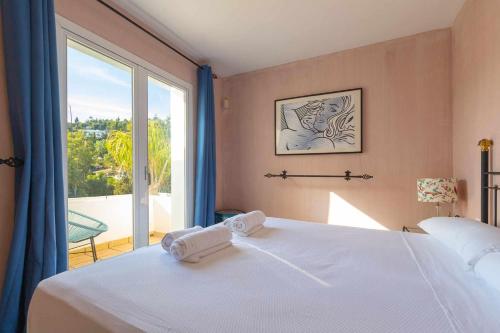 a bedroom with a bed and a large window at Golf Duplex con piscina en La Quinta Golf Marbella in Málaga