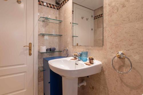 een badkamer met een witte wastafel en een douche bij Golf Duplex con piscina en La Quinta Golf Marbella in Málaga