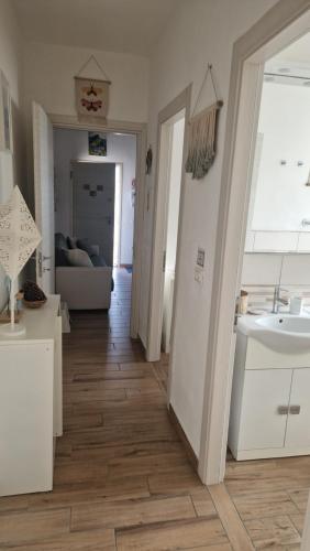 een keuken en een woonkamer met een houten vloer bij Igea Mare in Bellaria-Igea Marina