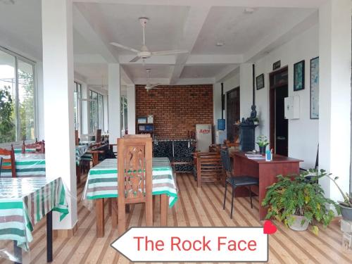 a room with tables and chairs and a brick wall at The Rock Face in Ella