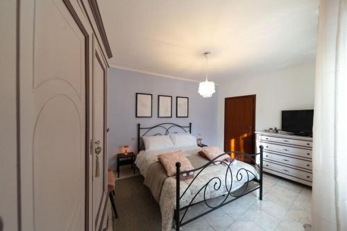 a bedroom with a bed and a tv and a dresser at Alle porte del Montefeltro - Maison Torriana in Torriana