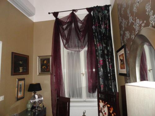 a window with red curtains in a room at Boudoir Budapest Apartment in Budapest