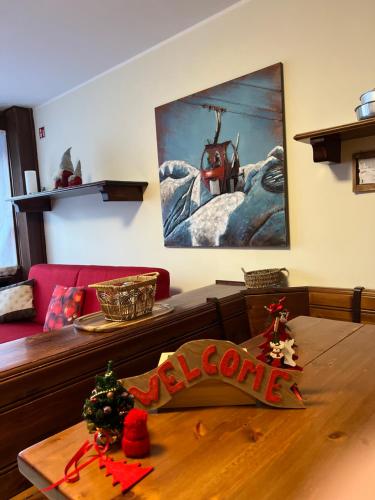 uma sala de estar com uma mesa com um cartaz de Natal em Cervinia – Matterhorn Apartments em Breuil-Cervinia
