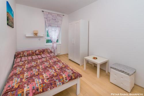 a small bedroom with a bed and a table at City break apartment in Čakovec