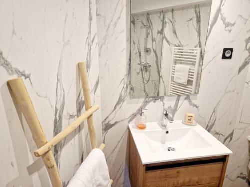 a bathroom with a sink and a mirror at L'Instant Détente in Barneville-Carteret