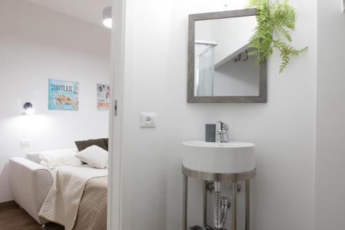 a bathroom with a sink and a mirror and a bed at Incantevole Loft - Centro Storico- Wi-Fi- Ad un passo da tutto in Terracina