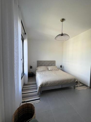 une chambre avec un lit dans une pièce blanche dans l'établissement Domaine d'Arca - Aragon 12 - 4 pers - 2 chambres - étage 2, à Porto-Vecchio