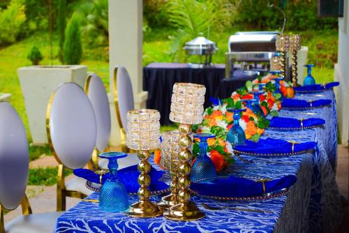 a table with a blue table cloth and glasses on it at Enaiteru in Oyugis