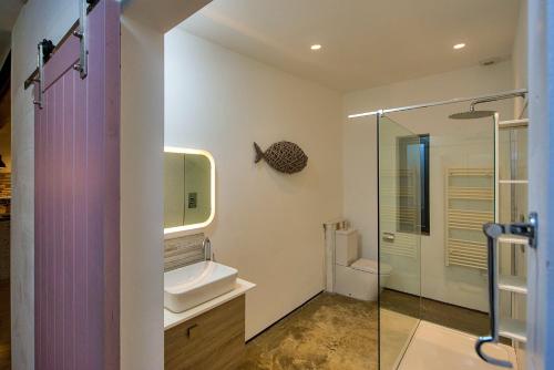 a bathroom with a sink and a glass shower at Finest Retreats - Sand Barn in Stalham