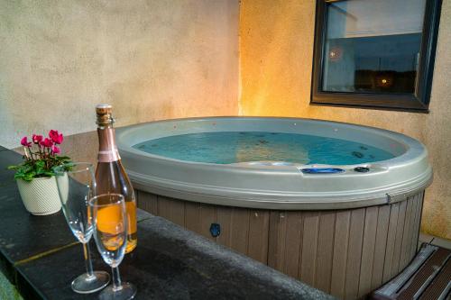 a hot tub with a bottle of champagne and two wine glasses at Finest Retreats - Sea Barn in Stalham