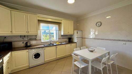 cocina con mesa, mesa blanca y sillas en Ellegance by Check-in Portugal, en Vilamoura