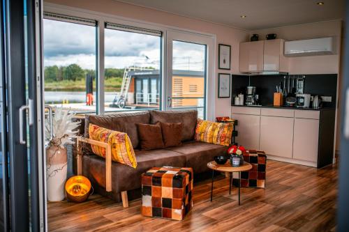 a living room with a couch and a kitchen at Floatinghouses Bärwalder See in Klitten