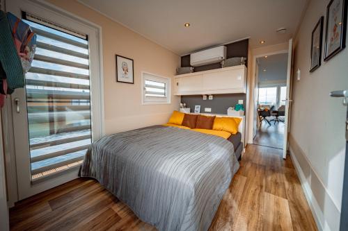 ein Schlafzimmer mit einem Bett und einem großen Fenster in der Unterkunft Floatinghouses Bärwalder See in Klitten
