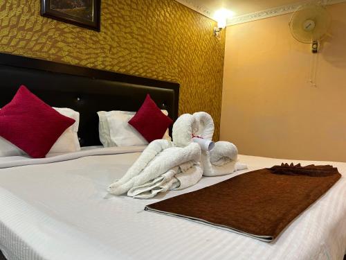 duas toalhas numa cama num quarto de hotel em Hotel Opera em Bahāsi