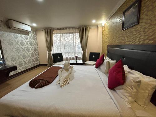 um quarto com uma cama grande e um animal em Hotel Opera em Bahāsi