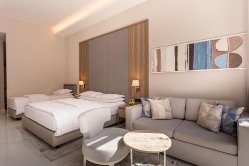 a hotel room with two beds and a couch at Hyatt Regency Kotor Bay Resort in Kotor