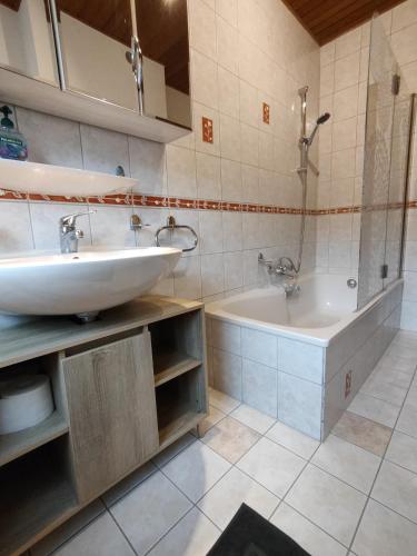 a bathroom with a sink and a bath tub at Ferienwohnung Hennessy 