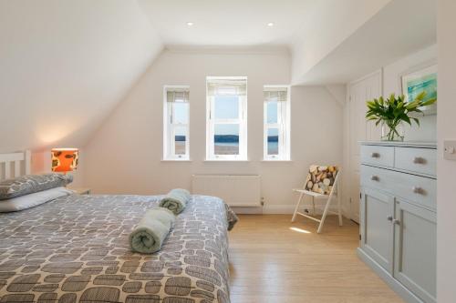 Un dormitorio con una cama y dos ventanas. en 5 Hartland House, en Woolacombe