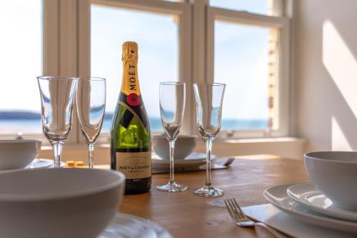 una botella de vino sentada en una mesa con copas de vino en 5 Hartland House, en Woolacombe