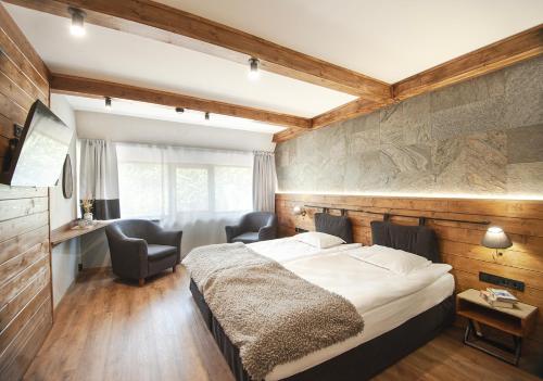 een slaapkamer met een bed, een bureau en stoelen bij "Park Hotel Ela" in Borovets