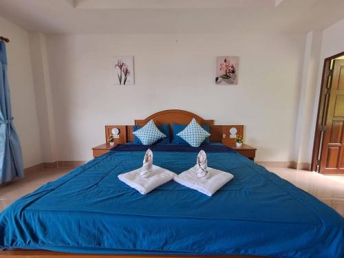 a blue bed with two pairs of shoes on it at Pailin Hill Hotel in Patong Beach