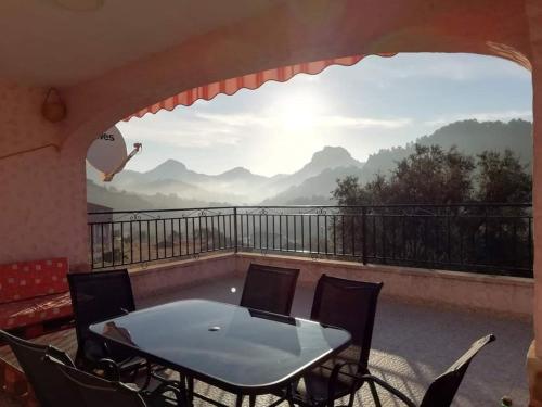 a table and chairs on a balcony with a view at Casa Rural E Puente del Segura in Elche de la Sierra