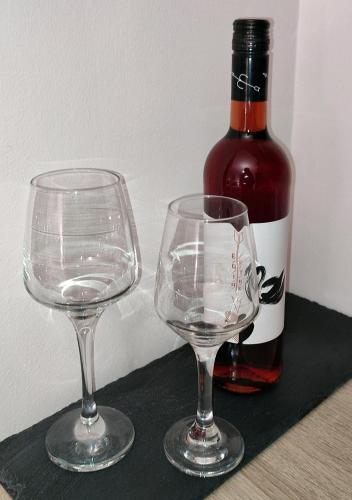 two wine glasses sitting next to a bottle of wine at LD Studio Larissa in Larisa