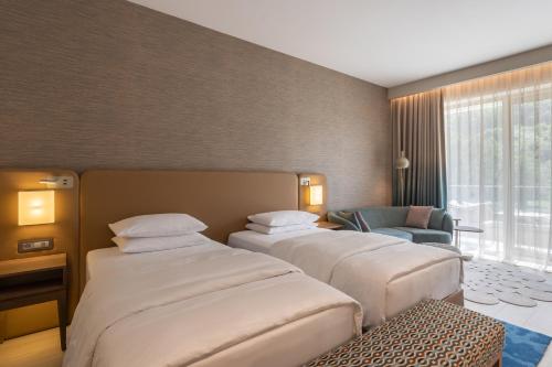 a hotel room with three beds and a chair at Hyatt Regency Kotor Bay Resort in Kotor