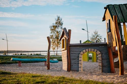 a playground with a small play house and a slide at Floatinghouses Bärwalder See in Klitten