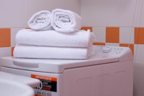 une pile de serviettes posée sur une machine à laver dans l'établissement MINERVA HOUSE, à Rapallo