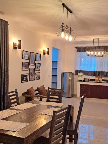 a dining room and kitchen with a table and chairs at Enaiteru in Oyugis