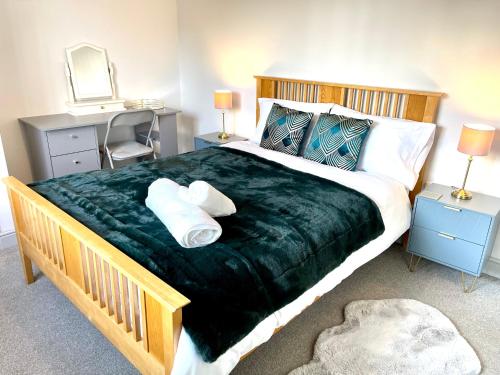 ein Schlafzimmer mit einem großen Bett mit zwei Kissen in der Unterkunft Stylish Cosy and Bright Apartment - Fantastic Location - Perfect for Business or solo travellers in Bishops Stortford