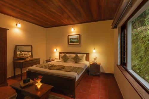 a bedroom with a bed and a large window at Emerald by Nature Resorts and Stays in Ooty