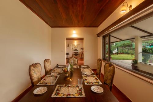 a dining room with a long table and chairs at Emerald by Nature Resorts and Stays in Ooty