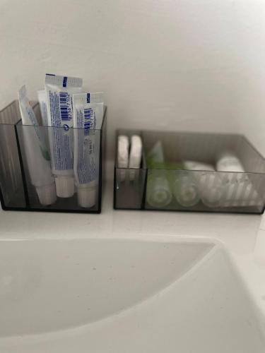 two containers of toothbrushes and toothpaste sitting on a counter at Chez Auguy et Deborah in Antwerp