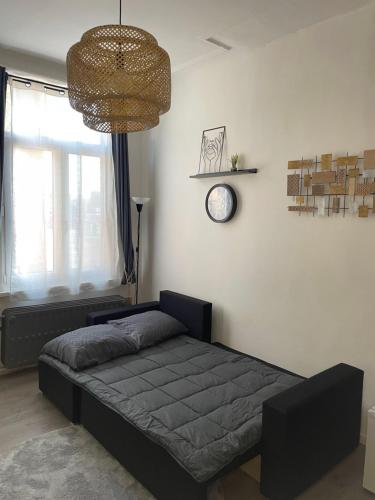 a bedroom with a bed and a clock on the wall at Chez Auguy et Deborah in Antwerp