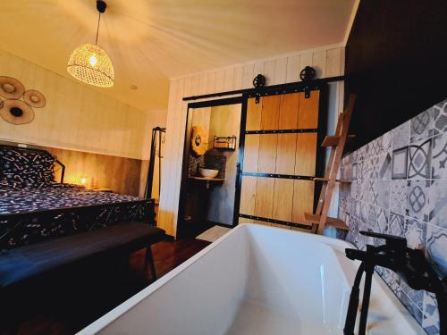 a bathroom with a bath tub and a bed at Gîte Chez Simone in Houffalize