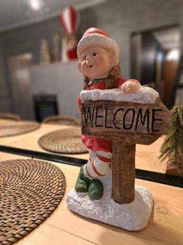 a santa claus figurine holding a welcome sign at Gîte Chez Simone in Houffalize