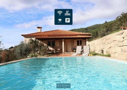 a villa with a swimming pool in front of a house at MyStay - Casa do Carmo in Alvite
