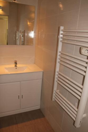 une salle de bain blanche avec un lavabo et un miroir dans l'établissement Studio 20, Héliopolis D au village naturiste, au Cap d'Agde