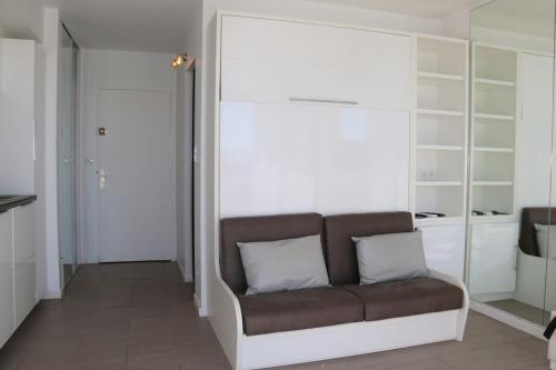 - un salon avec un canapé et 2 oreillers dans l'établissement Studio 20, Héliopolis D au village naturiste, au Cap d'Agde
